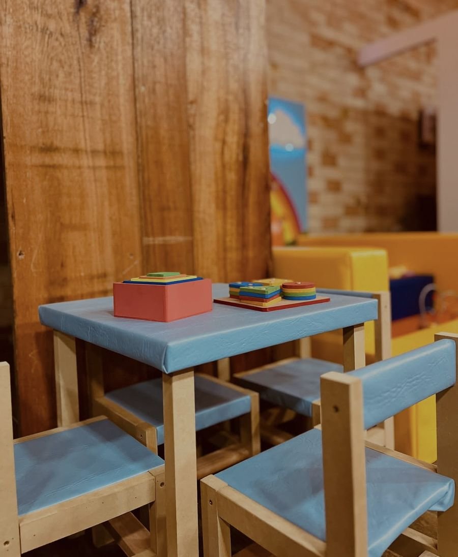 Mesa e cadeirinhas infantis azuis com brinquedos de encaixe